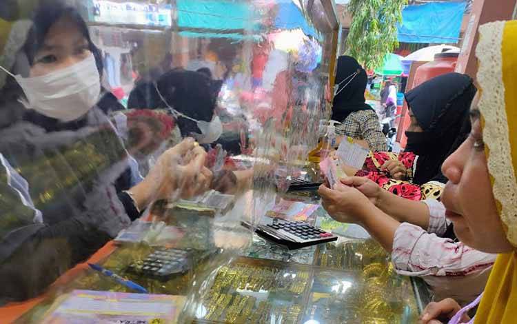 Seorang calon pembeli sedang memilih emas perhiasan yang bakal dijadikan investasinya, Sabtu, 19 Juni 2021.