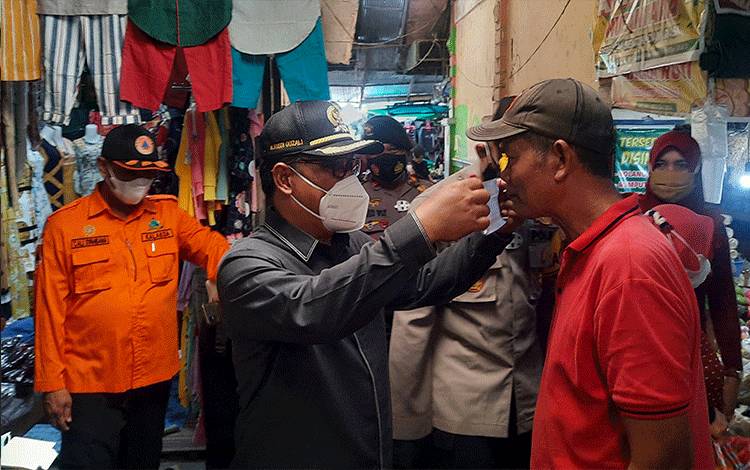 Ketua DPRD Kobar Rusdi Gozali saat memakaikan masker pada pedagang di Pasar Indra Sari Pangkalan Bun.