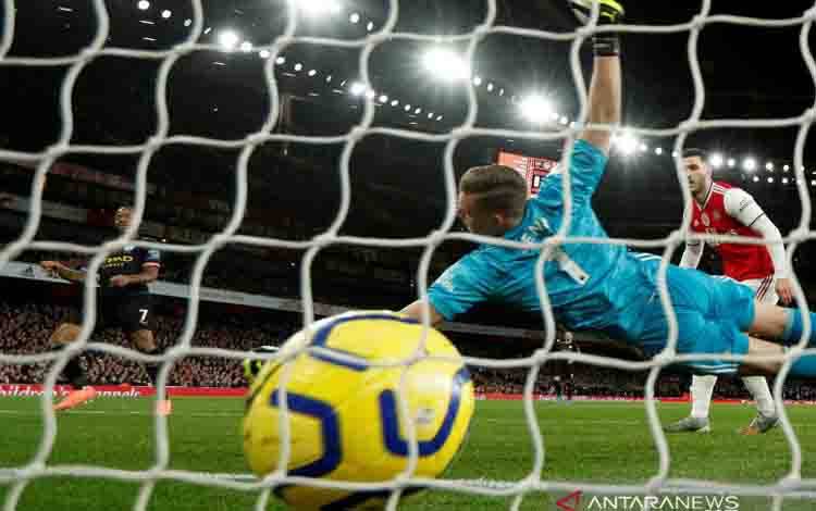 Pemain Manchester City Raheem Sterling (kiri) mencetak gol ke gawang Arsenal dalam laga lanjutan Liga Inggris di Emirates Stadium, London, Inggris, Minggu (15/12/2019). City menang 3-0