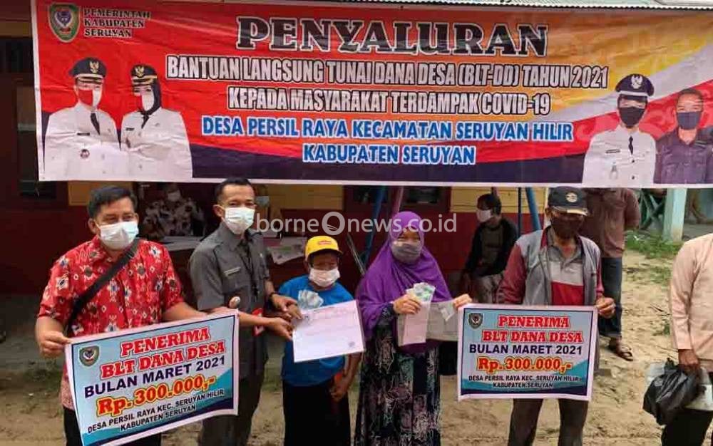 Pj Kades Persil Raya Robi Kuswanto saat menyerahkan BLT-DD kepada salah satu warga penerima manfaat, Jumat, 25 Juni 2021