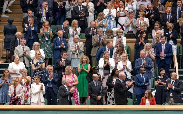 Para penonton memberikan aplaus dengan berdiri untuk Sarah Gilbert, Profesor Universitas Oxford perancang vaksin Oxford/AstraZeneca, yang menyaksikan pertandingan tenis Wimbledon dari podium kehormatan untuk keluarga kerajaan Inggris, Senin (28/6/2021)