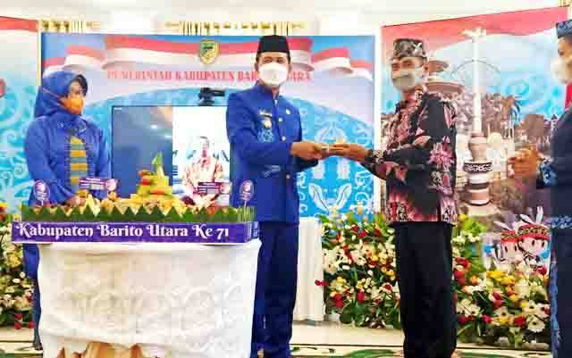 Bupati Barito Utara, H Nadalsyah saat menyerahkan potongan tumpeng pertama peringatan HUT Kabupaten ke 71 kepada mantan Wakil Bupati Barito Utara periode 2013-2018, Drs Ompie Herby, Selasa 29 Juni 2021 di rumah jabatan bupati.?
