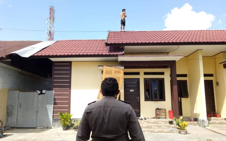 Pemuda Ini Nekat Naik Ke Atas Gedung Apotek dan Asrama Polisi