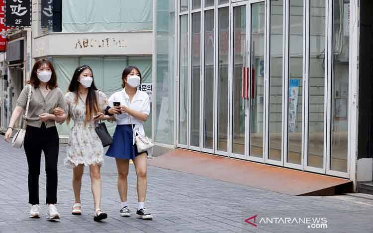 Warga berjalan di kawasan pusat kota Seoul, Korea Selatan (9/7/2021). Pemerintah Korsel mulai Senin (12/7/2021) untuk pertama kalinya akan memperketat kegiatan di Seoul dan wilayah sekitarnya, karena kasus COVID-19 terus mencatat rekor harian secara nasional. ANTARA FOTO/REUTERS/ Heo Ran/aww.