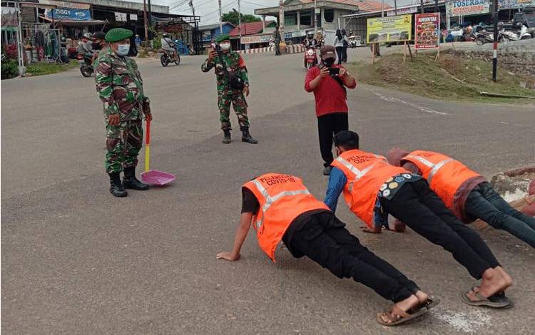 Tim yustisi saat memberikan sanksi sosial kepada warga yang kedapatan melanggar prokes di Kota Puruk Cahu.