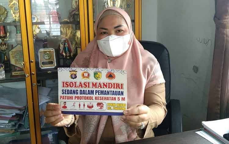 Lurah Panarung Evi Kahayanti menunjukkan stiker yang digunakan untuk rumah warga Isoman