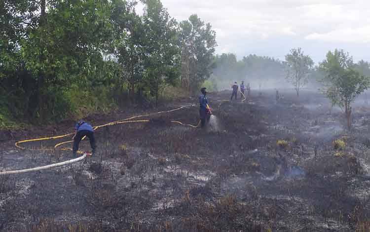 Petugas sedang memadamkan kebakaran lahan di Jalan Pramuka, Sampit, Selasa, 13 Juli 2021.
