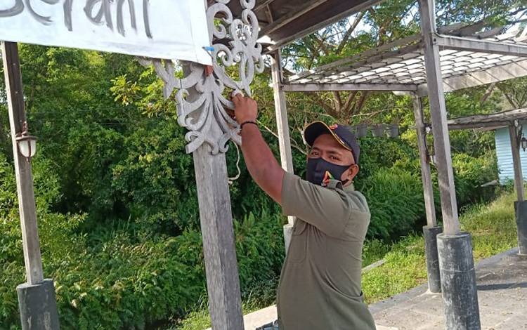 Anggota Satpol PP Kota Palangka Raya menurunkan spanduk protes Covid-19 yang dipasang di kawasan taman kuliner Taman Tunggal Sanggomang, Jalan Yos Sudarso, Selasa 13 Juli 2021