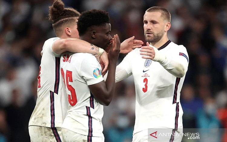 Pemain sayap tim nasional Inggris Bukayo Saka (tengah) dihibur oleh Kalvin Phillips (kiri) dan Luke Shaw setelah eksekusinya gagal dalam adu penalti final Euro 2020 melawan Italia di Stadion Wembley, London, Inggris, Minggu (11/7/2021). ANTARA/REUTERS/POOL/Carl Recine