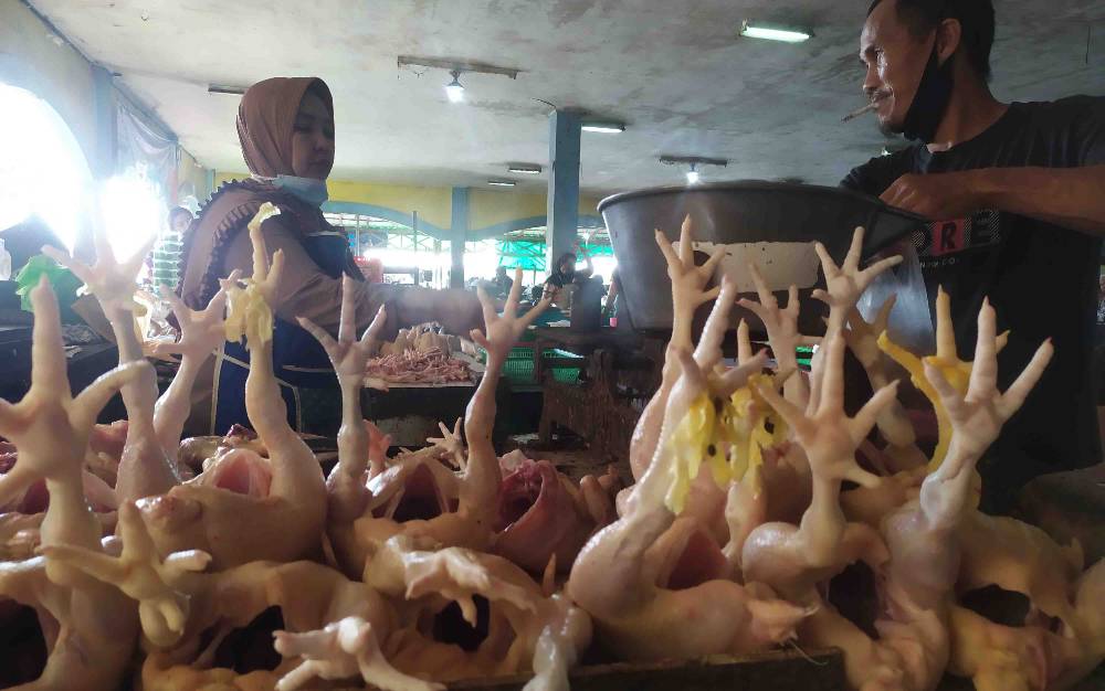 Penjual daging ayam bertransaksi dengan salah seorang pembeli di Pasar Ikan Mentaya Sampit, Kotawaringin Timur