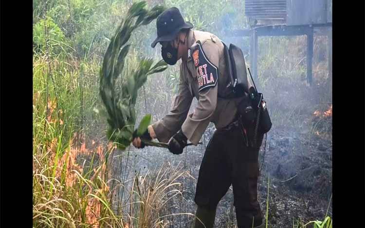 Petugas sedang memadam api pada lahan yang terbakar di Jalan Pelita Barat, Sampit, Sabtu 24 Juli 2021