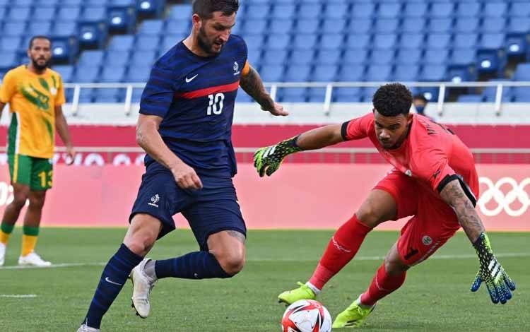 Penyerang Prancis Andre-Pierre Gignac (tengah) mencoba melewati kiper South Africa Ronwen Williams (kanan) sebelum mencetak gol dalam pertandingan Grup A Olimpiade Tokyo 2020 di Saitama Stadium pada 25 Juli 2021