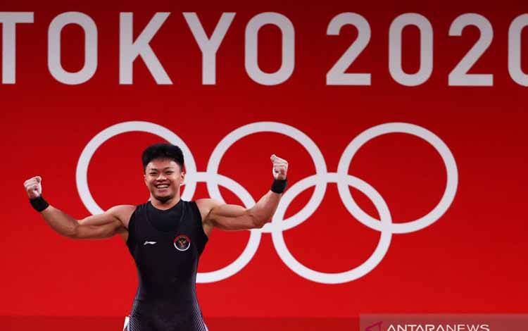 Lifter Indonesia Rahmat Erwin Abdullah usai melakukan angkatan di saat laga grup B angkat besi kelas 73 kg putra Olimpiade Tokyo 2020, di Tokyo International Forum, Tokyo, Jepang, Rabu (28/7/2021). Rahmat memimpin Grup B di nomor 73 kg putra dengan total angkatan 342 kg