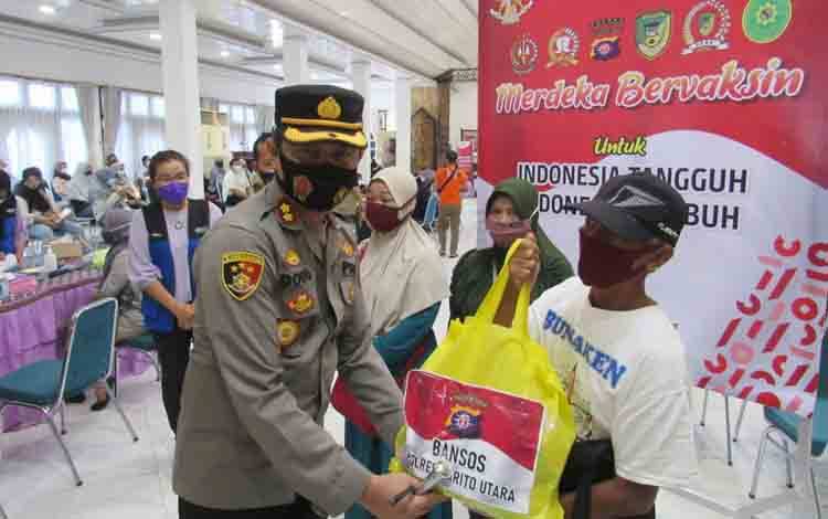 Polres Barito Utara Gelar Vaksinasi Massal Tahap 2 dan Bagikan Bansos kepada Warga