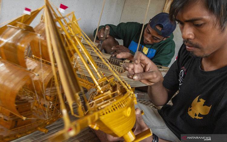 Perajin menyelesaikan pembuatan kerajinan perahu layar berbahan bambu di workshop Aliebambuart, Desa Randumulya, Pedes, Karawang, Jawa Barat, Sabtu (24/7/2021). ANTARA FOTO/M Ibnu Chazar/aww.