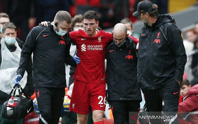 Bek kiri Liverpool Andy Robertson (kedua kiri) dipapah tim medis meninggalkan lapangan dalam laga persahabatan pramusim melawan Athletic Bilbao di Stadion Anfield, Liverpool, Inggris, Minggu (8/8/2021). (ANTARA/REUTERS/ACTION IMAGES/Lee Smith)