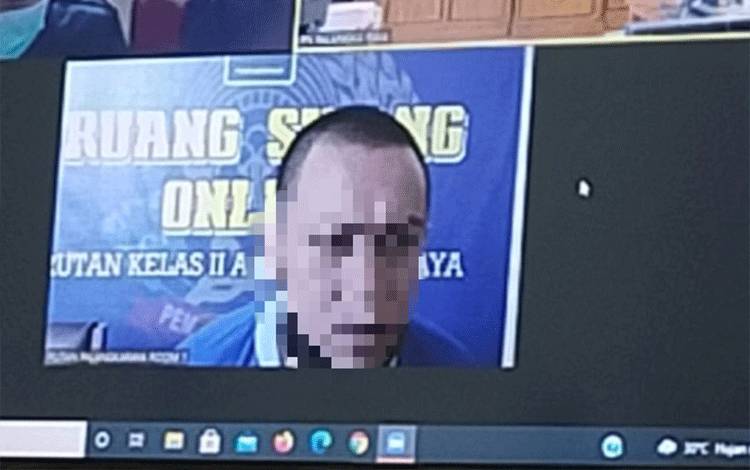 Terdakwa saat menjalani sidang secara virtual di Pengadilan Negeri Palangka Raya.