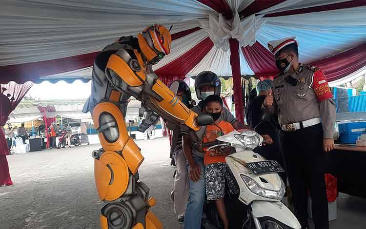 Maskot Robot Transformer Bumble Bee, saat menyapa warga yang mengikuti vaksin Drive Thru di Satlantas Polres Kobar.