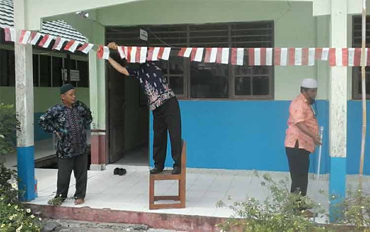 Para guru MIN 3 Kapuas saat memasang pernak-pernik sambut HUT ke-76 Kemerdekaan Republik Indonesia