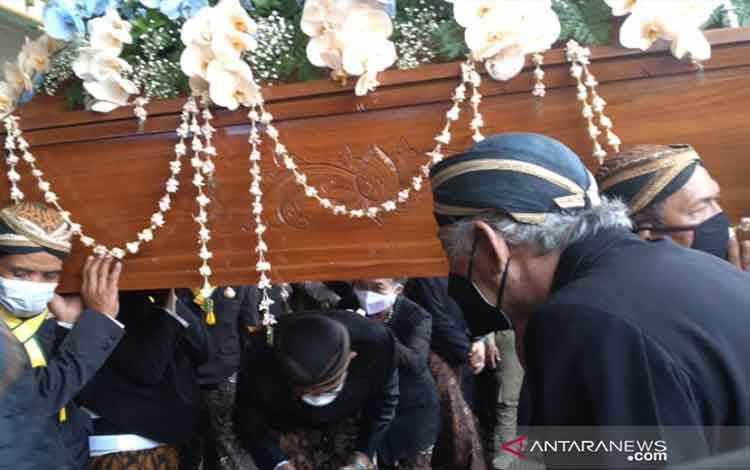 Salah satu putra sedang menjalani tradisi "brobosan" di bawah peti mati Adipati Mangkunegara IX di Pura Mangkunegaran Surakarta, Minggu (15/8/2021). ANTARA/Aris Wasita