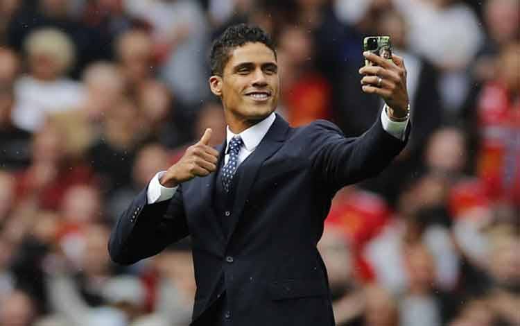 Raphael Varane saat diperkenalkan kepada pendukung Manchester United menjelang pertandingan melawan Leeds United di Old Trafford, Manchester, Inggris, 14 Agustus 2021. (REUTERS/PHIL NOBLE)