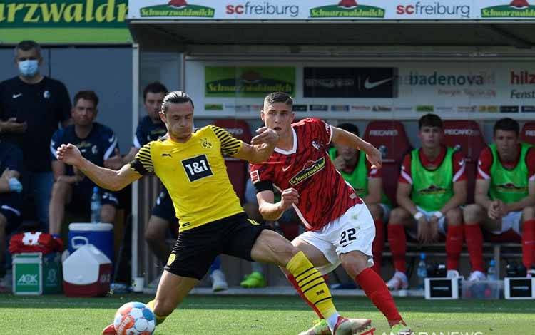 Gelandang SC Freiburg Roland Sallai (kanan) berebut bola dengan bek Borussia Dortmund Nico Schulz dalam lanjutan Liga Jerman di Stadion Dreisam, Baden-Wuerttemberg, Jerman, Sabtu (21/8/2021)