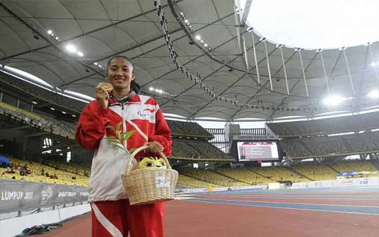 Pelari difabel Indonesia, Putri Aulia, berpose selepas menyabet medali emas ASEAN Para Games 2017 nomor 400 meter T13 putri di Kuala Lumpur, Malaysia, Selasa (19/9/2017). (ANTARA News/Istimewa)