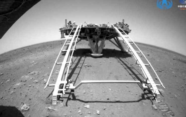 Penjelajah China Zhurong dari misi Tianwen-1 berkendara menuruni jalur pendarat ke permukaan Mars, dalam tangkapan layar ini diambil dari video yang dirilis oleh Administrasi Luar Angkasa Nasional China (CNSA) Sabtu (22/5/2021)