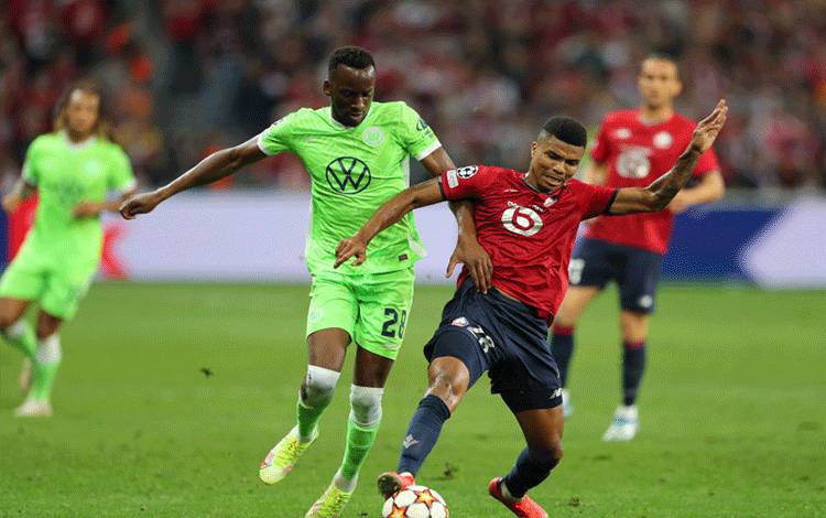 Pemain Lille Reinildo Mandava berduel dengan pemain VfL Wolfsburg Dodi Lukebakio ketika kedua tim berbagi poin setelah seri 0-0 dalam pertandingan Grup G Liga Champions di Stade Pierre-Mauroy, Villeneuve-d'Ascq, Prancis, 14 September 2021. (REUTERS/PASCAL ROSSIGNOL)