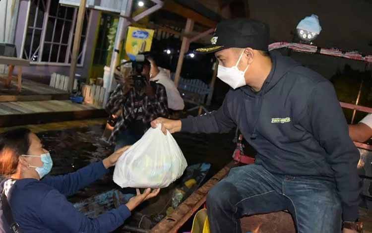 Wali Kota Palangka Raya, Fairid Naparin saat menyerahkan bantuan bagi warga terdampak banjir.