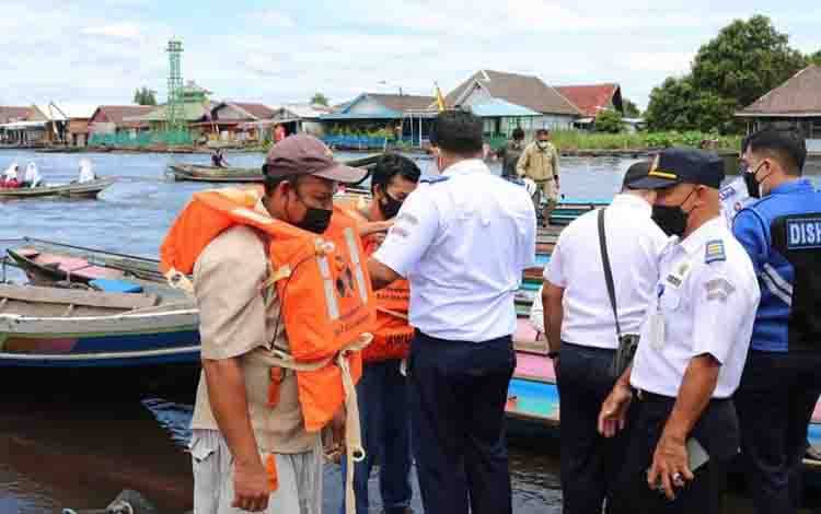 Insan Perhubungan Kobar saat mensosialisasikan keselamatan angkutan sungai dan bagikan life jaket