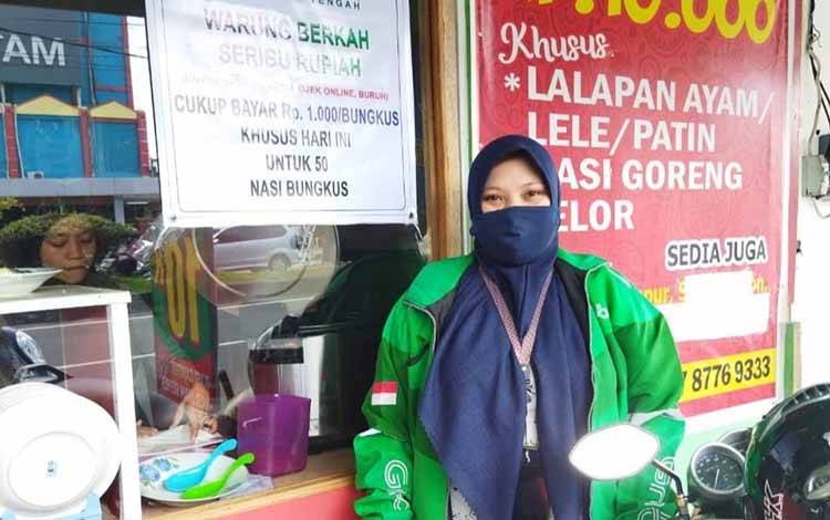 Yuliani wanita yang berprofesi sebagai Ojek online saat membeli Warung Berkah Seribu Rupiah