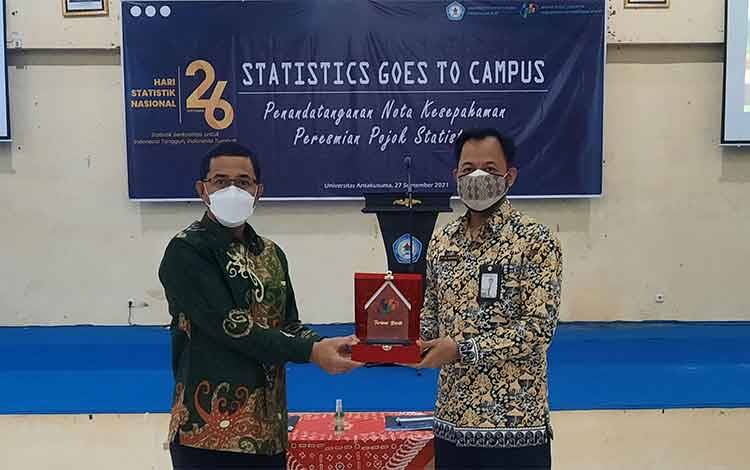 Kepala BPS Kobar Yul Ismardani (kanan) berikan plakat kepada Rektor Universitas Antakusuma Jeffrie Wattimena, dalam kegiatan MoU dan Peresmian Pojok Statistik.