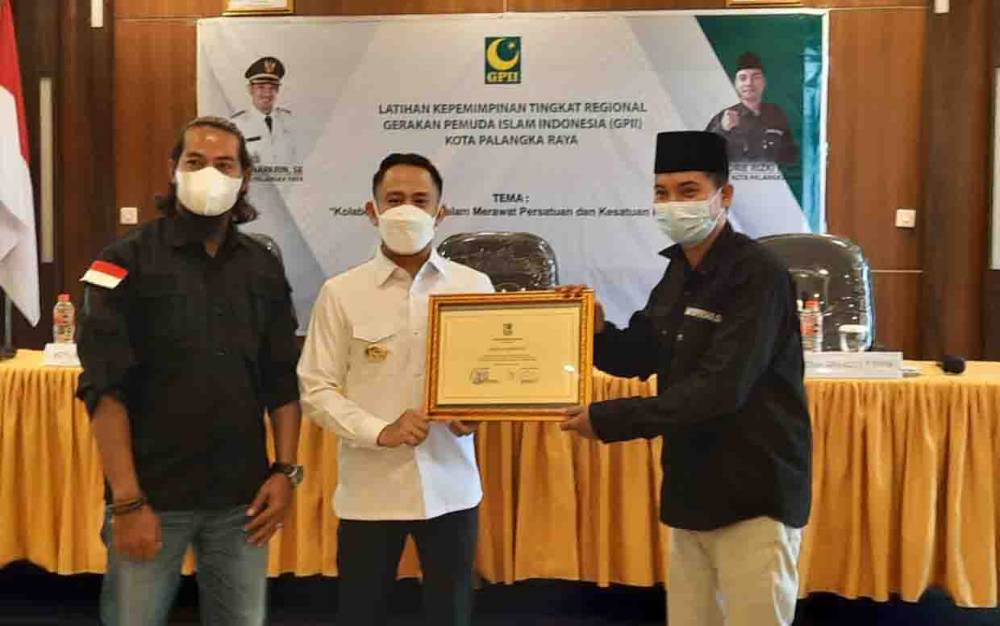 Wali Kota Palangka Raya Fairid Naparin saat menerima plakat dari Ketua GPII