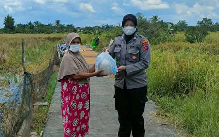 Personel Polwan Polres Kapuas saat menyalurkan bantuan paket sembako untuk warga pada Jumat, 1 Oktober 2021.
