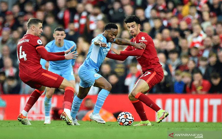 Aksi pemain Manchester City Raheem Sterling mencoba melewati dua pemain Liverpool Jordan Henderson dan Curtis Jones dalam pertandingan Liga Inggris pekan ketujuh di Anfield pada 3 Oktober 2021. ANTARA/REUTERS/PETER POWELL