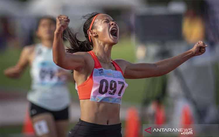 Pelari Jawa Barat Tyas Murtiningsih berselebrasi usai memenangi final nomor lari 100 meter putri PON Papua di Stadion Atletik Mimika Sport Center, Kabupaten Mimika, Papua, Rabu (6/10/2021). Tyas meraih medali emas, sementara pelari Jabar lainnya Erna Nuryanti meraih medali perak dan pelari Bengkulu Hasruni meraih medali perunggu. ANTARA FOTO/Aditya Pradana Putra/pras.