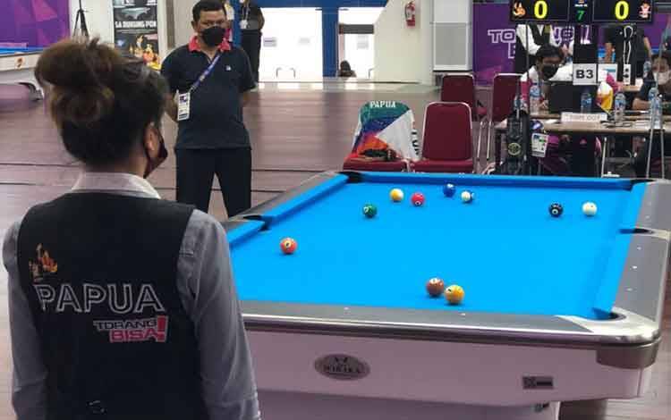 Pebiliar Papua, Silviana Lu, memperhatikan meja biliar sebelum menentukan arah pukulan di gim pertama babak final bola 10 tunggal putri Pekan Olahraga Nasional Papua di Gor Biliar SP5 Mimika, Rabu. (Antaranews/Roy Rosa Bachtiar)