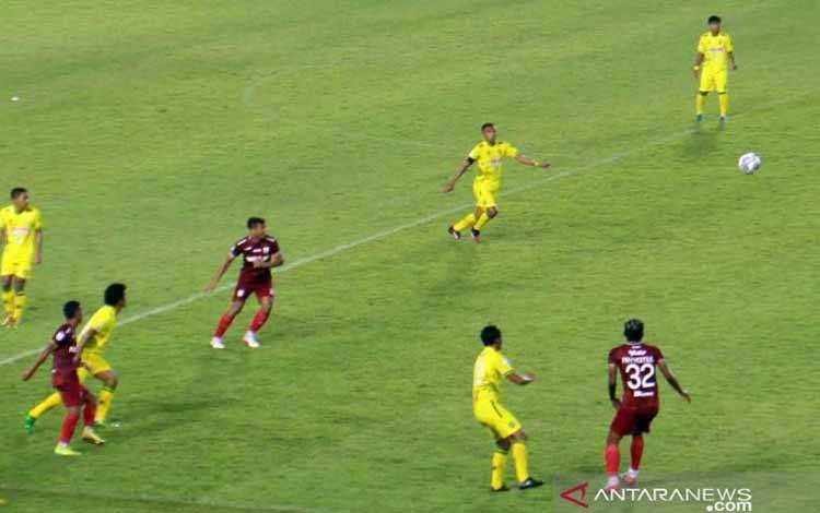 Pemain nomor punggung 32 Persis Solo, Fary Komul (kostum merah merah) memberikan umpan bola dan mendapat pengawalan pemain Hizbul Wathan (HW) FC dalam pertandingan grup C Liga 2 Musim 2021 di Stadion Manahan Solo, Senin (18/10/2021) malam