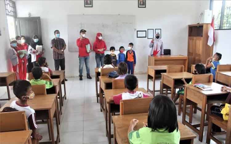 Pascabanjir, Camat Kamipang Katingan Berikan Bingkisan dan Alat Tulis untuk Peserta Didik