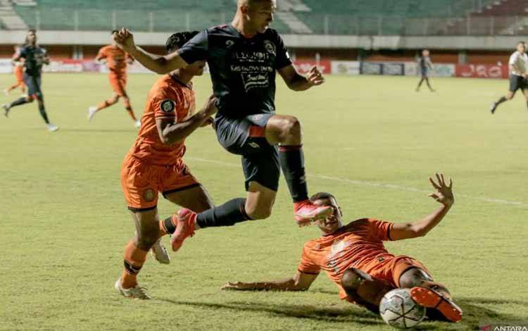 Pesepak bola Arema FC Dendi Santoso (tengah) berebut bola dengan pesepak bola Persiraja Banda Leonardo Lelis (kanan) saat pertandingan Liga 1 di Stadion Maguwoharjo, Sleman, DI Yogyakarta, Sabtu (23/10/2021)