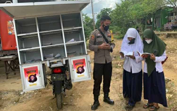Personel Polsek Kapuas Timur saat menjalankan program Bajaka presisi untuk meningkatkan anak gemar membaca buku.