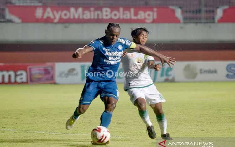Pesepak bola Persib Bandung Igbonefo (kiri) berebut bola dengan pesepak bola Persebaya Surabaya Supriadi (kanan) dalam laga perempat final Piala Menpora 2021 di Stadion Maguwoharjo, Sleman, D.I Yogyakarta, Minggu (11/4/2021). Persib berhasil mengalahkan Persebaya dengan skor 3:1