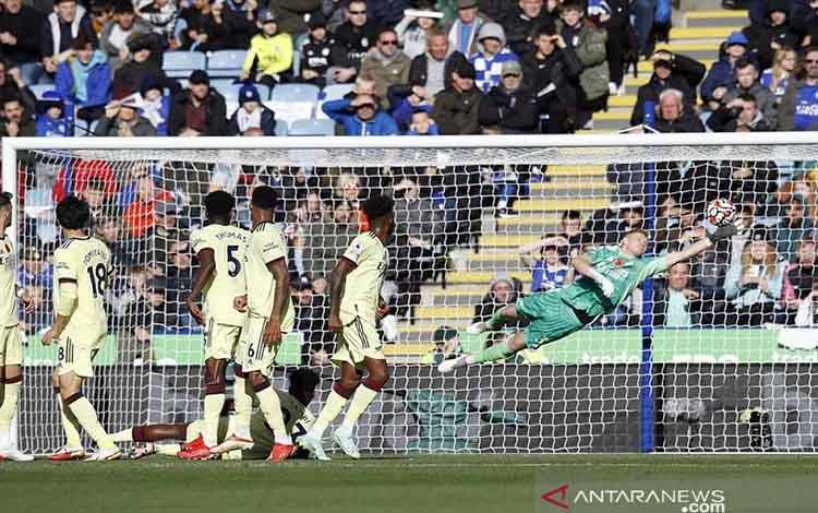 Kiper Arsenal Aaron Ramsdale (kanan) melakukan aksi penyelamatan gemilang untuk menggagalkan bola tendangan bebas gelandang Leicester James Maddison dalam laga lanjutan Liga Inggris di Stadion King Power, Leicester, Inggris, Sabtu (30/10/2021). (ANTARA/REUTERS/Peter Nicholls)