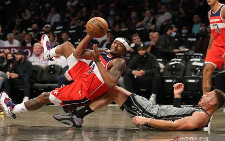 Ilustrasi - Pebasket Washington Wizards Bradley Beal (kiri) berupaya mengoper bola ke rekannya yang dihadang pebasket Brooklyn Nets Blake Griffin (kanan) dalam laga NBA, di Barclays Center, .Brooklyn, New York, Ameriksa Serikat, Senin (25/10/2021). Brooklyn Nets berhasil mengalahkan Washington Wizards 104 - 90ANTARA FOTO/Reuters-Brad Penner-USA TODAY Sports/hp.