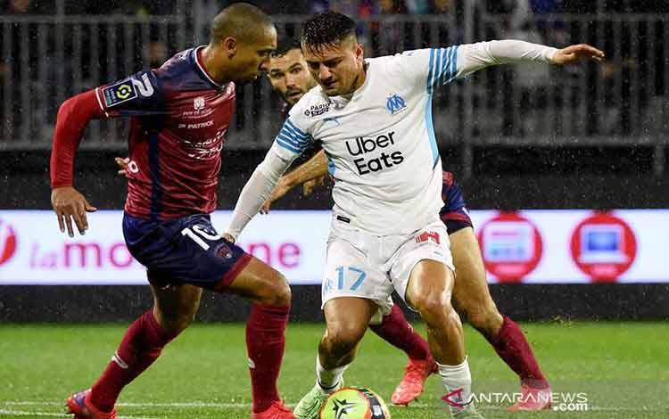Penyerang sayap Marseille Cengiz Under (kanan) berusaha menggiring bola melewati gelandang Clermont Jonathan Iglesias dalam laga lanjutan Liga Prancis di Stadion Gabriel-Montpied, Clermont, Prancis, Minggu (31/10/2021) waktu setempat. (ANTARA/AFP/Jean-Philippe Ksiazek)
