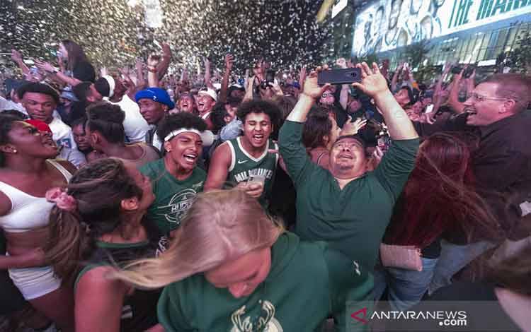 Sejumlah suporter Milwaukee Bucks merayakan gelar NBA pertama mereka dalam 50 tahun setelah Game 6 Final NBA di Milwaukee, Wisconsin, AS (20/7/2021). Milwaukee Bucks mengalahkan Phoenix Suns 105-98 untuk memenangi kejuaraan NBA. ANTARA FOTO/Mark Hoffman/Milwaukee Journal Sentinel-USA TODAY Sports via Reuters/aww.