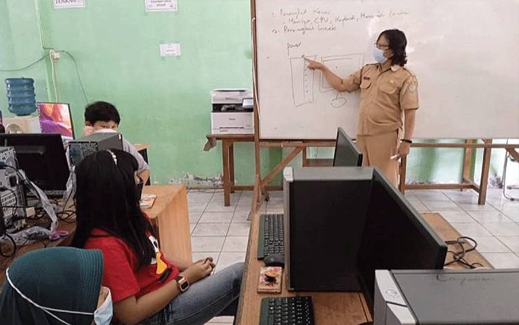 Instruktur komputer Mihewu Daya Hawino sedang menyampaikan materi kursus kepada peserta.