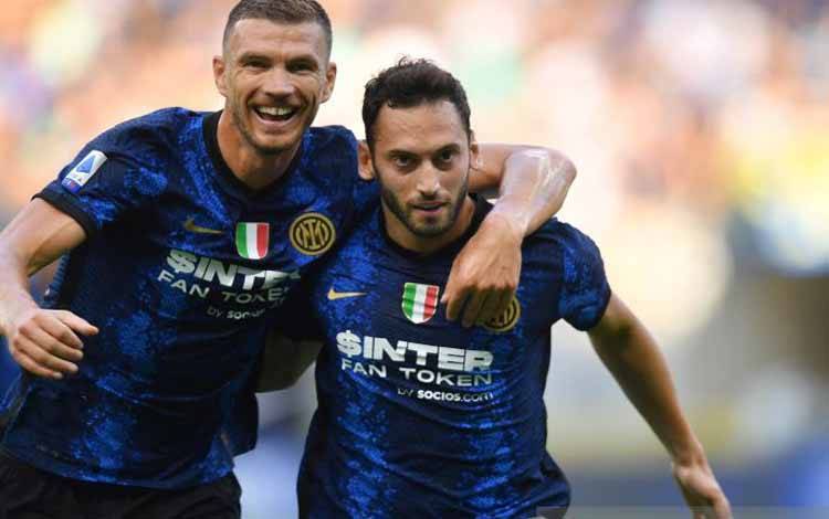 Pemain sepak bola Inter Milan Hakan Calhanoglu melakukan selebrasi dengan Edin Dzeko setelah mencetak gol kedua saat bertanding melawan Genoa dalam Serie A di San Siro, Milan, Italia, Sabtu (21/8/2021)