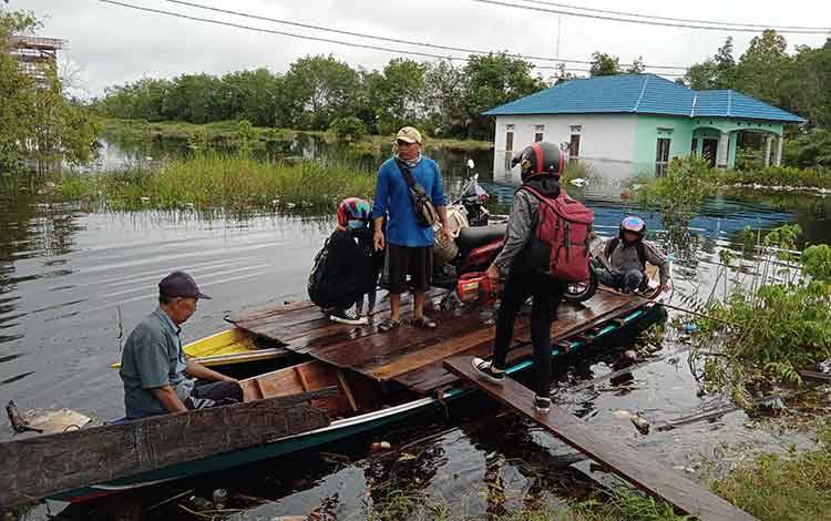 Perahu Kelotok Jadi Andalan Bantu Melintasi Banjir di Jalan Tumbang Nusa